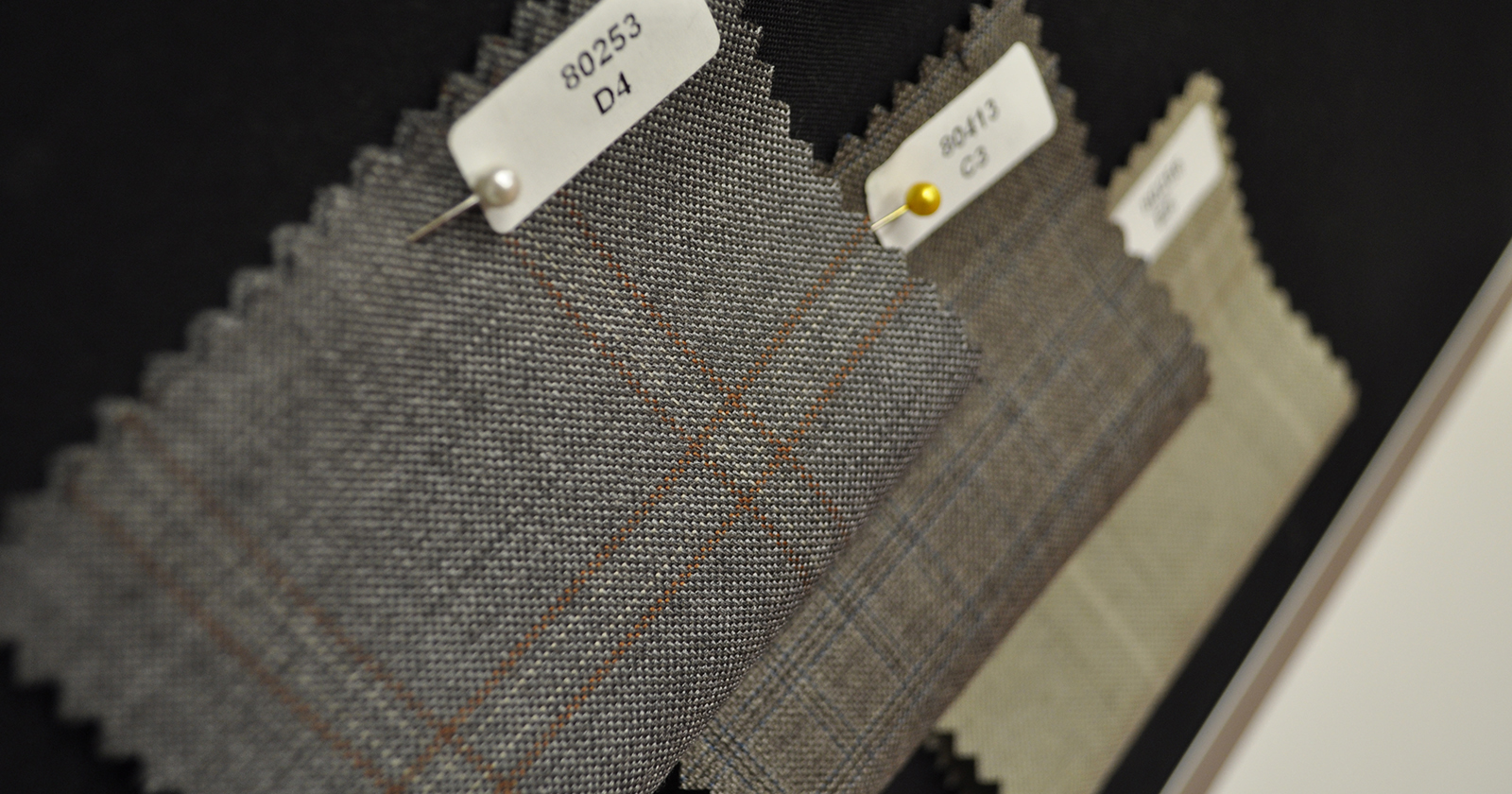 Small samples of fabrics with shades of gray and dark and light browns.