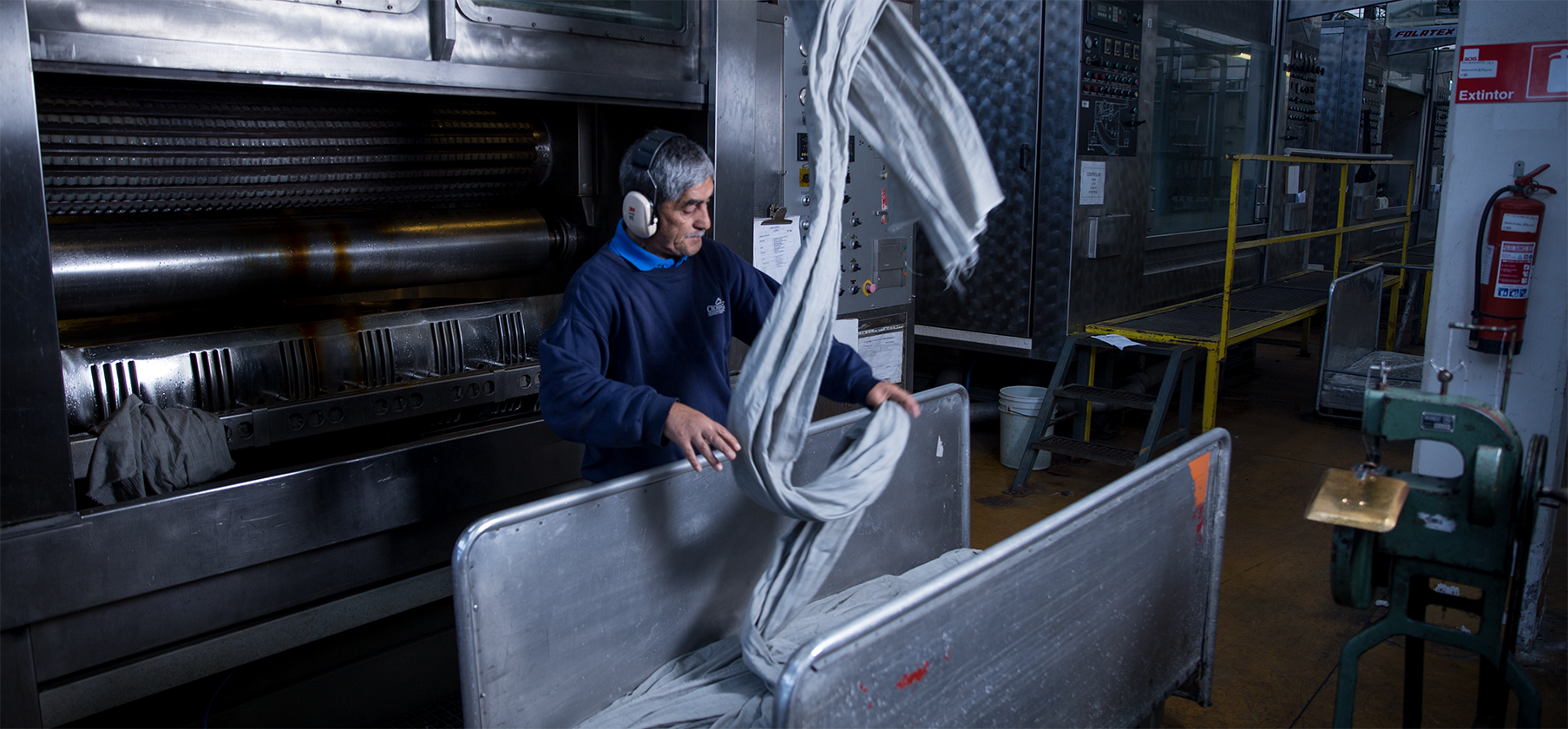 A man handling fabrics inside a factory.